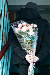 手指周年纪念日情人节男孩背着鲜花躲在身后美丽的图片