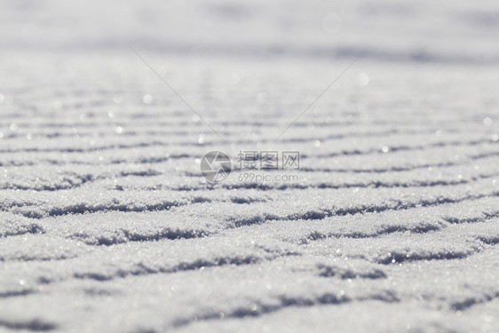 离奇的季节冰雪表面冬季过去降雪后下漂流形成强风在地表上的异常现象照片以浅深的田地角向上贴近抽象的图片