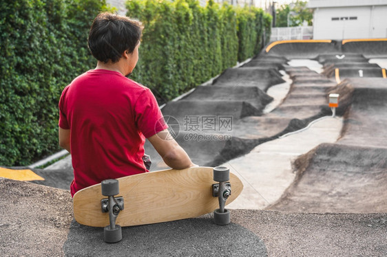 腿滚动人们亚洲男子与冲浪skate或滑板一起坐在轮冰公园中日出时间超过浮轮曲线外形运动健康和时尚等相光模糊点的日出时间图片