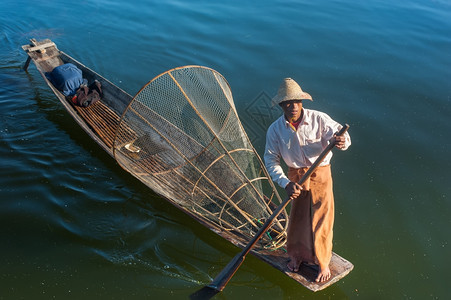 户外传统的食物缅甸河旅行目的地缅甸竹船上渔夫以传统方式与手工制作的Inle网湖捕鱼使用手工制造的Inle湖缅甸旅游目的地图片