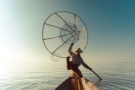 桨轮廓状态缅甸河旅行目的地缅甸竹船上渔夫以传统方式与手工制作的Inle网湖捕鱼使用手工制造的Inle湖缅甸旅游目的地图片
