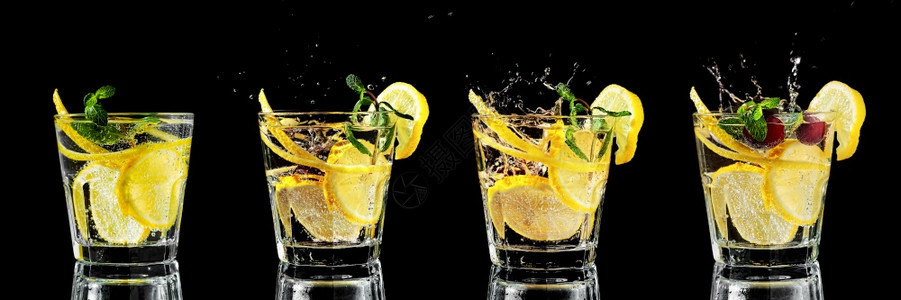 食谱四杯加柠檬汁或莫吉托鸡尾酒四杯加柠檬或莫吉托鸡尾酒加柠檬和薄荷饮料在黑色背景下喷洒的冰块上落入玻璃杯中柑橘甜的图片