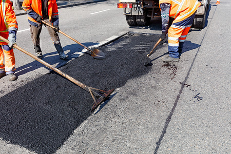 等级公路工人作组准确精地将路段部分道的新鲜沥青用于修筑道路以便复建设中的部分道路并配有复印空间图像工兵旅在道路建设中用铲子清理部图片