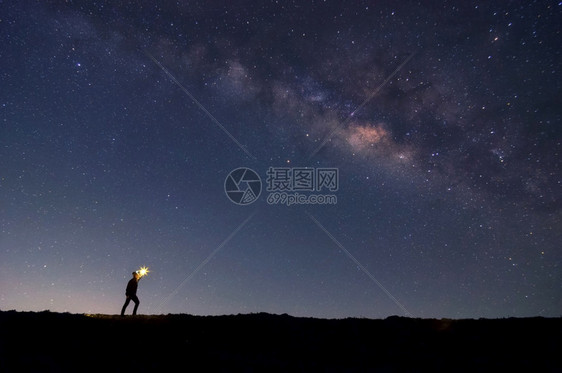 宇宙悬崖高的左手着火软焦点登山者在岩石峰上找到目标在恒星和银河系下搜索晚上成功或胜利领导概念高比音上面有噪领袖图片