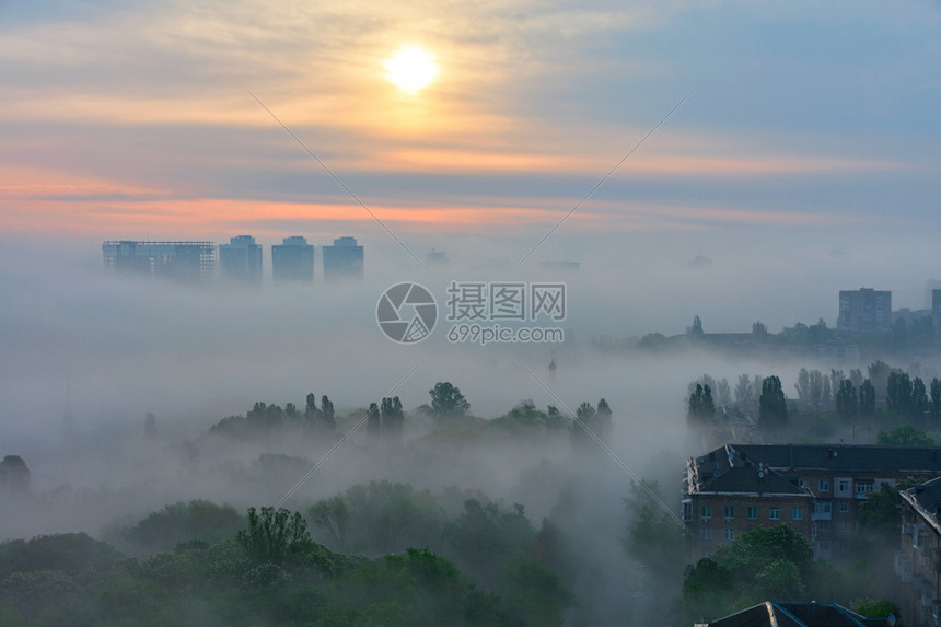 蒙清晨一阵浓雾像黄昏一样在城市公园的房屋和树木之间蔓延在太阳升起的柔软触碰下清晨升起的阳光照亮了轻地唤醒沉睡的城市笼罩着浓雾就像图片