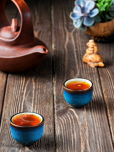 多肉植物极好的合身两碗红茶桌子上一个粘土茶壶仪式新鲜酿成的黑茶蒸汽在杯子上方升起温暖柔软的灯光黑暗木本底密闭图片