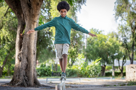非裔美国人一名洲卷发男孩站在铁栏杆上伸展的手臂站着可爱的面部图片