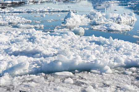 冰峡湾山在格陵兰的海洋上漂浮冰与水中蓝色天空的反射相映像而成白色的图片
