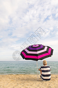 维林克男人在海滩的雨伞下放假遮着树荫海岸夏天图片