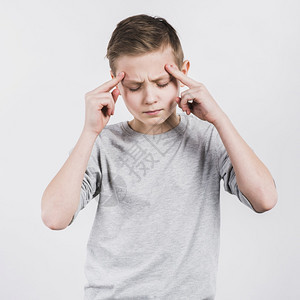 情绪化的焦虑晕眩站在白种背景下着头痛的重病严男孩图片