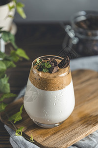 时髦的玻璃杯加水滴IcedDalgonaCoffa咖啡一种流行的fluffy奶油鲜泡咖啡由百草枯和深巧克力装饰潮人食物图片