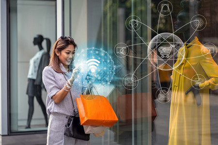 为了在线的市场使用智能手机检查网上购物订单的亚洲妇女通过全新频道技术完成在百货商店玻璃杯旁边配有服装并在部门中心欢乐地采取行动以图片
