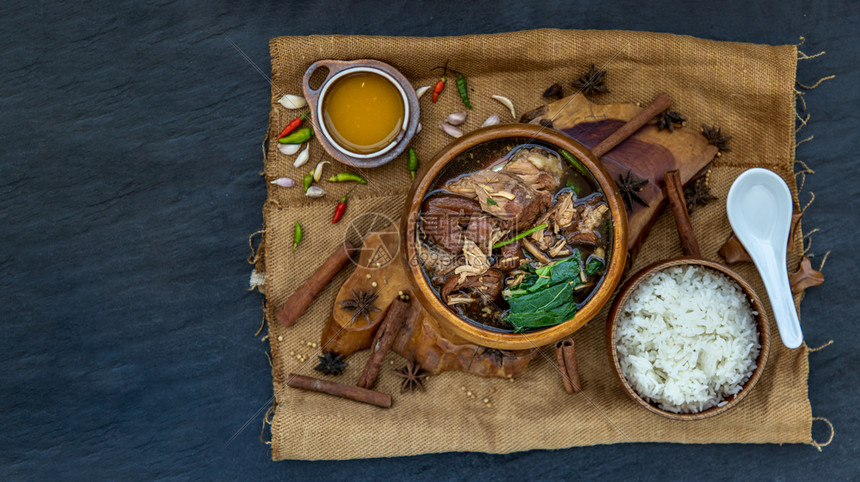 吃脂肪配有甜肉汁酱的斜腿猪配有茉米饭食品选择焦点和罐头图象复制空间辛辣的图片