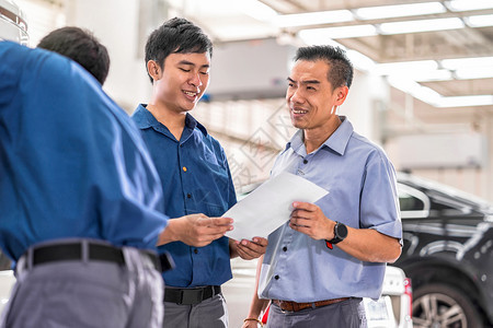 工程师亚洲机械向客户介绍维修服务中心的工作这是展厅汽车修理和工作概念协议的一部分亚洲机械师就维修服务向客户讲述并展示了有关工作顾图片