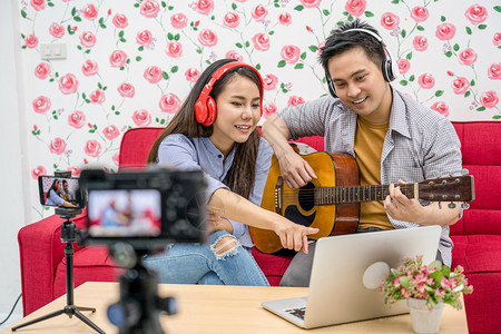 视频博客在线的服用已婚夫妇亚洲Vlogger通过社交媒体频道手机播放和分享音乐通过手机笔记本电脑照相机录制视频现场vlog和im图片