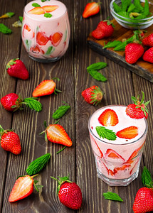 乡村奶昔果汁两个杯子草莓鸡尾酒配在旧木本底上草莓和蘑菇小秘诀制造冰雪的原料放在滑顶视图上背景图片
