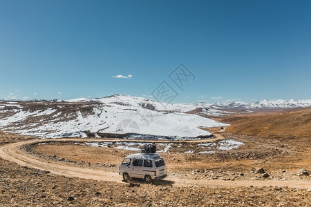 街道游客德赛巴基斯坦AstoreGilgitBaltistan的Deosai平原公园有一辆地方公共汽车顶上有行李沿未铺面的公路行图片