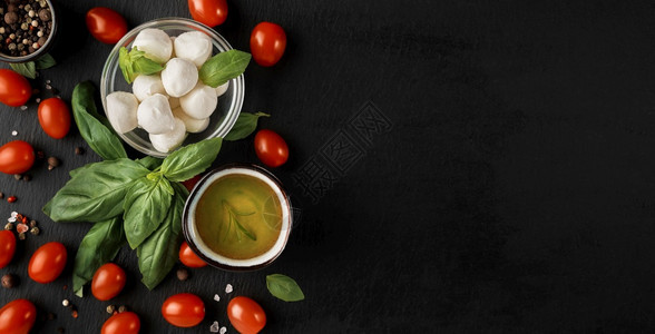食物Mozzarella和樱桃西红柿配有叶盐和辣椒以及黑石板布局用于制作Caprese沙拉喜怒无常胡椒图片