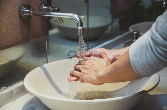 爆发与铬水龙头和进行近身洗手在浴室预防科罗纳流行自我负责清洁手卫生冠状菌保护概念中防止科罗纳流行健康脸盆图片