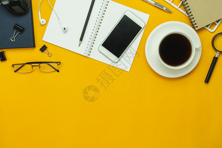 黄色的互联网表格顶端视图航空附件的中像办公桌背景概念Flat各种物体移动电话笔和咖啡用耳机挂在现代黄锈纸上并有复制空间的蜂鸣器药图片