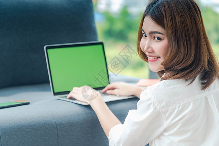 普通的打字在家工作参加庭办公室膝上型电脑在线会议的妇女使用笔记本的企业家女商妇坐在沙发技术上新的正常生活方式快乐女人打键盘手提电图片