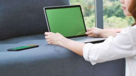 健康桌面成功在家工作参加庭办公室膝上型电脑在线会议的妇女使用笔记本的企业家女商妇坐在沙发技术上新的正常生活方式快乐女人打键盘手提图片