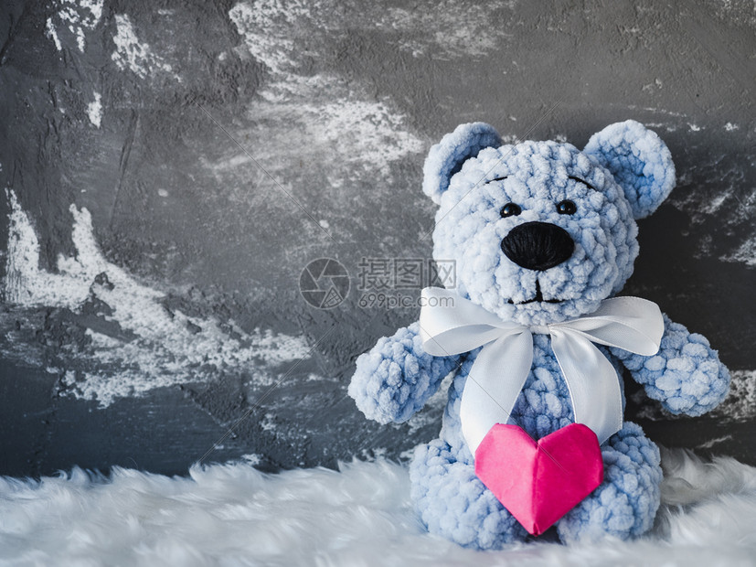 灰色的Brightpluh玩具坐在白格子上拿着红心室摄影棚近身室内向爱人家亲戚朋友和同事恭喜有红心的Brightploh玩具保持图片