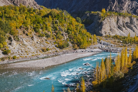 季节吉泽目的地在巴基斯坦吉尔特俾提斯坦的秋天风景中Ghizer河的绿松石蓝水穿过Gahkuch的森林在HinduKush山脉周围图片