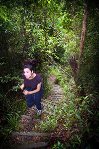 跑一位活跃的年轻女子在茂密的丛林中徒步旅行跑复制图片