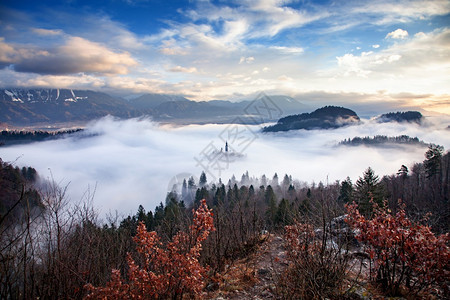 爬坡道高山一种清晨与小岛上的玛利亚占居地朝圣教堂和山崩中的布莱德城堡和朱力安阿尔卑斯一起雾密的弥漫之夜图片