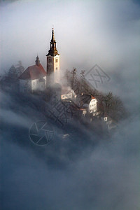 清晨与小岛上的玛利亚占居地朝圣教堂和山崩中的布莱德城堡和朱力安阿尔卑斯一起雾密的弥漫之夜湖户外爬坡道图片