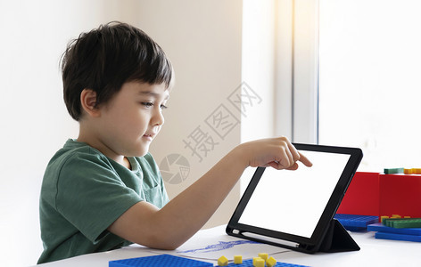 笔记本电脑企业孩子呆在家里看关于Tleblet的漫画孩子使用数字平板电脑搜索信息在互联网上寻找家庭作业日校19课锁定社会分化学习图片