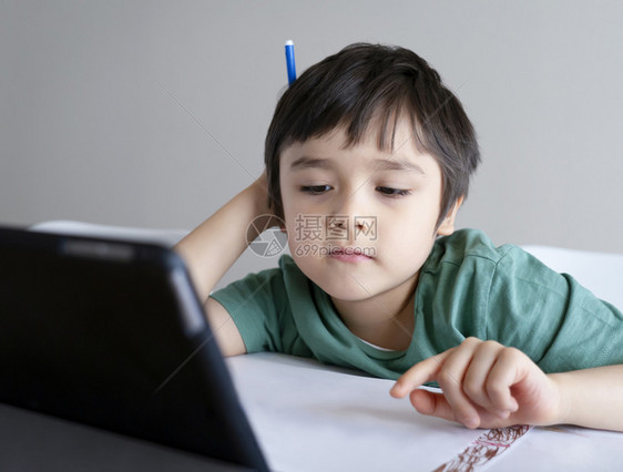 医疗的为了他孩子呆在家里看关于Tleblet的漫画孩子使用数字平板电脑搜索信息在互联网上寻找家庭作业日校19课锁定社会分化学习在图片