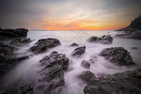 云海洋雅日落时温柔的海浪黑暗沙滩前方有石块泰国乔莱姆亚武科萨迈特公园Rayong海景长照射拍摄图片
