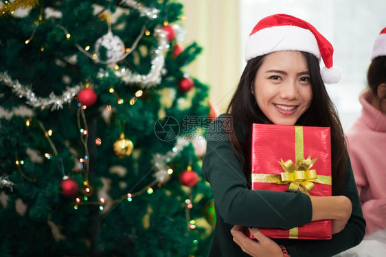 女士带圣诞树装饰Xma和新年概念的礼物或以及圣诞树和装饰品的亚洲妇女说谎图片
