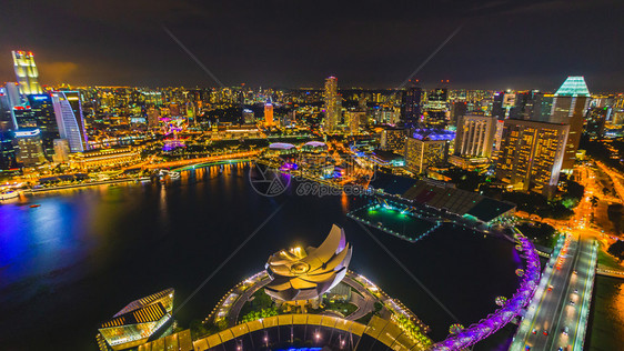 天空新加坡是夜间有彩色灯光和美丽水的城市是新加坡巡视多彩且野清晰的空中观运动焦点模糊的旅游企业在新加坡商业的地标图片