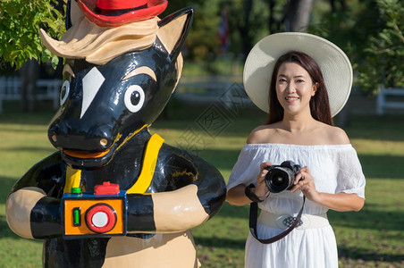 亚洲人成泰国清迈省市SanKamphaeng泰国清迈2018年月6日美丽的亚洲女孩在度假胜地放松身着白色礼服拿相机蒋图片