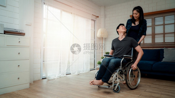 妻子安慰车祸后坐在家中轮椅上的丈夫图片