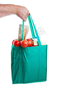 填充一只握着个环保袋的强力手包装满了杂货食品在白色背景上拍摄环保的藤蔓背景图片