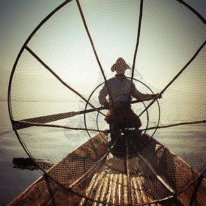 亚洲缅甸河旅行目的地缅甸竹船上渔夫以传统方式与手工制作的Inle网湖捕鱼使用手工制造的Inle湖缅甸旅游目的地户外著名图片