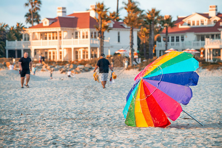女湿的乐趣日落时带观光游客的多彩海滩雨伞图片