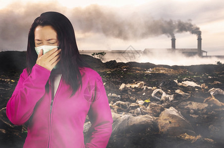 排气行业妇女打流感喷嚏妇女穿粉红色的冬季衣着身戴面罩在感冒和流健康概念下的鼻子上戴面罩反对空气污染背景车图片