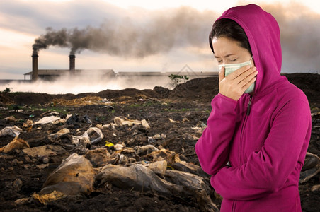 环境打喷嚏妇女流感妇女穿粉红色的冬季衣着身戴面罩在感冒和流健康概念下的鼻子上戴面罩反对空气污染背景城市图片
