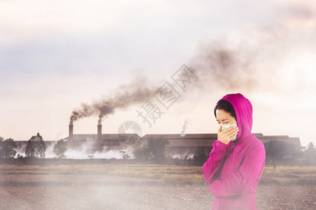 粉色的服装变暖妇女打流感喷嚏妇女穿粉红色的冬季衣着身戴面罩在感冒和流健康概念下的鼻子上戴面罩反对空气污染背景图片