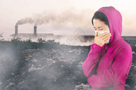 冬天生病的人妇女打流感喷嚏妇女穿粉红色的冬季衣着身戴面罩在感冒和流健康概念下的鼻子上戴面罩反对空气污染背景图片