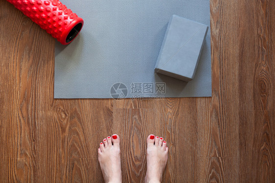 常规的身体按摩女人站在操垫和滚板前赤脚站在地上她将做午的锻炼综合体只有脚是可见的健康生活方式运动减重概念a健康生活方式体重下降概图片