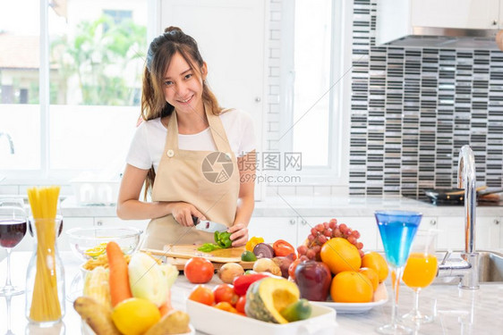 母亲亚洲美容女在厨房做饭和切菜餐桌上满食物和水果以庆祝节日和幸福概念为桌边人们和生活方式概念女孩看镜头厨师房间图片