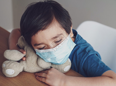 症状试过了一个男孩因胸口咳嗽而疲倦戴着医用面罩保护下午25点孩子玩具时睡着了孩子呆在家里保护冠状流感爆发和疾病保护污染图片