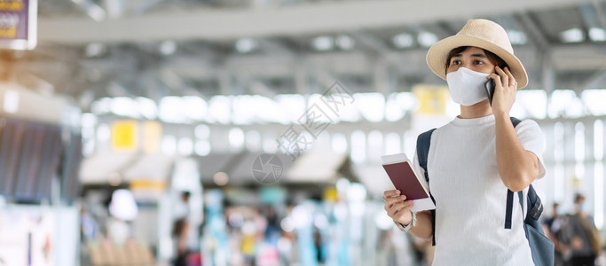 在机场持有护照和智能手机的面罩保护科罗纳感染亚洲女旅行者检查新正常航班以及根据COVID19概念进行的旅年轻成女青子在机场持有护图片