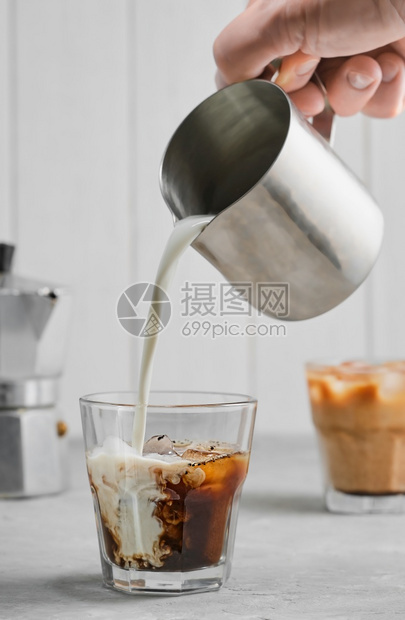 简单的溅运动咖啡泡在灰色混凝土桌上倒奶油展示了水的纹理和清新面貌冷咖啡有选择焦点垂直框架图片